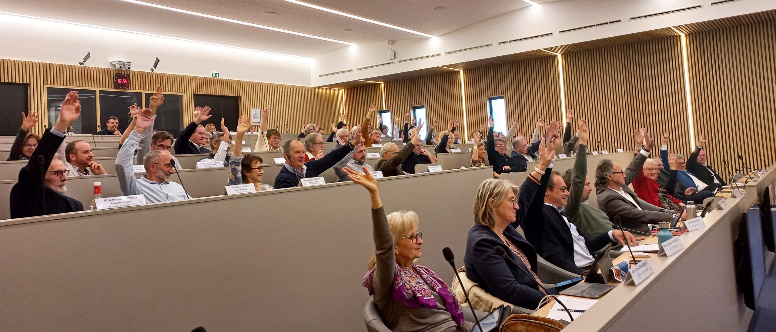 Les élus du Grand Périgueux sont assis, face à des micros et lèvent la main.