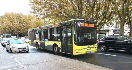 Un bus jaune circule en ville
