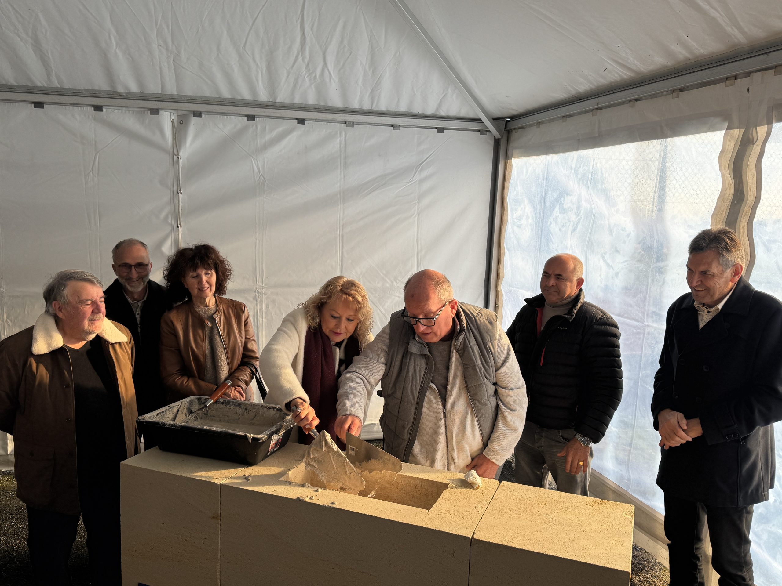 Le président du Grand Périgueux Jacques Auzou et la maire de Savignac-les-Églises Evelyne Roux enfouissent une capsule temporelle dans une pierre en guise de geste inaugural du chantier du pôle enfance de Savignac-les-Églises.