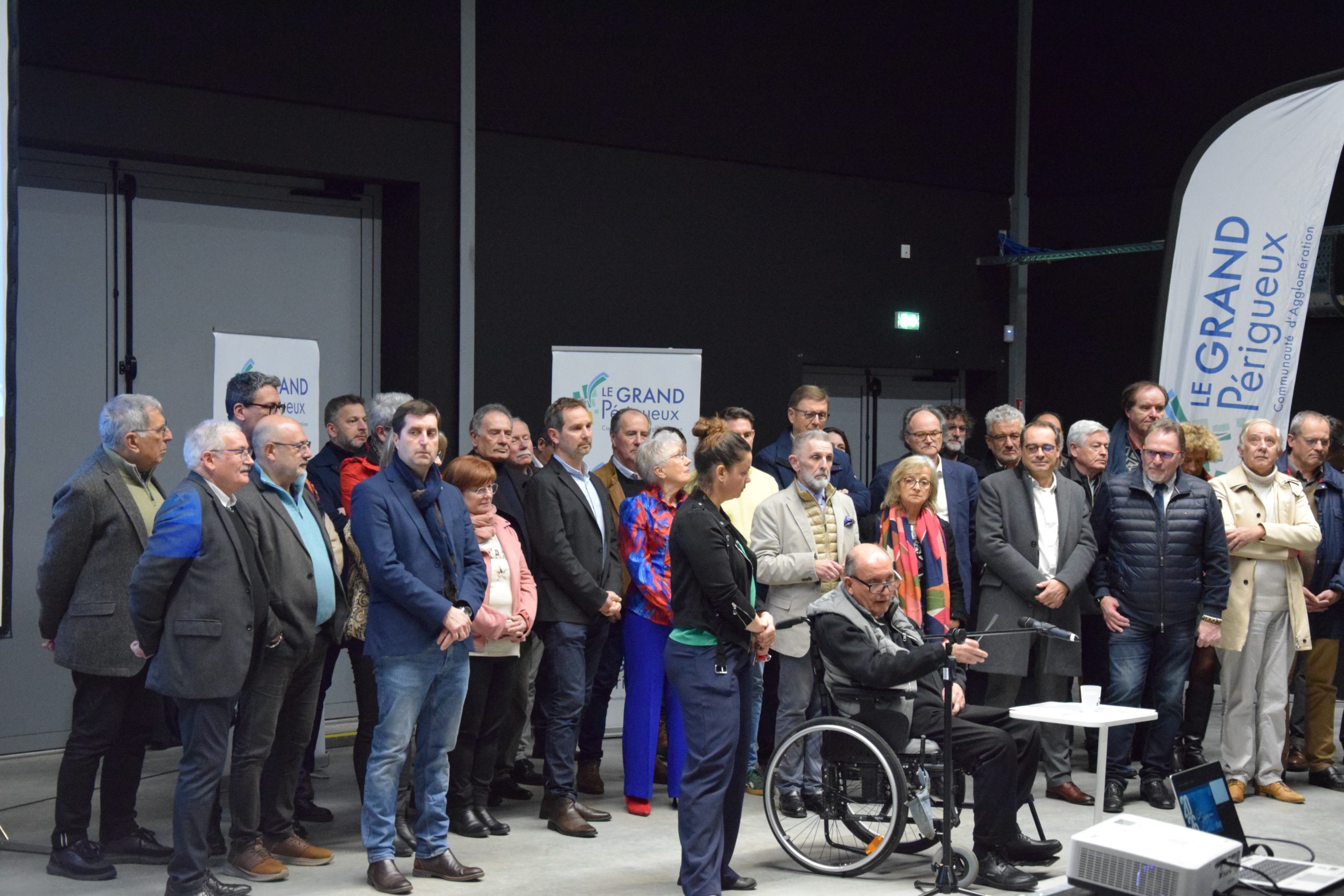 Jacques Auzou, devant un parterre d'élus pour les voeux aux personnalités. Derrière ce groupe de personnes, plusieurs roll up et une flamme au nom du Grand Périgueux