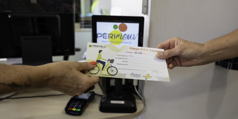 Deux mains tiennent un chèque sur lequel est écrit chèque.