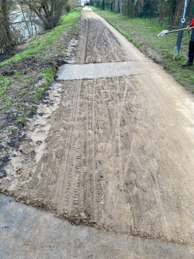 La voie verte est en cours de nettoyage après les inondations. Une longue portion de boue marron avec des sédiments a remplacé la voie.
