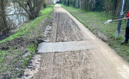 La voie verte est en cours de nettoyage après les inondations. Une longue portion de boue marron avec des sédiments a remplacé la voie.